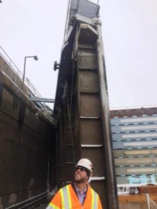 Army Corp of Engineers Project Manager Aaron Dunlop talking to reports at the bottom of the structure with one of the gates in the background